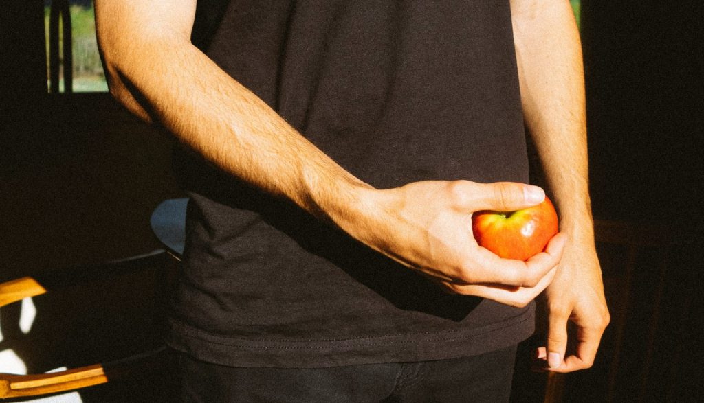 person holding orange and yellow round fruit